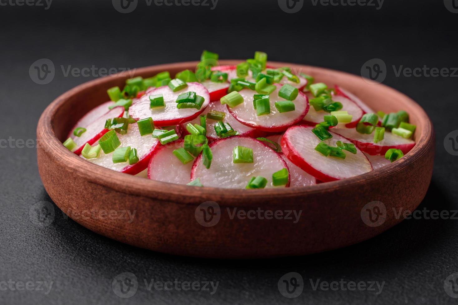 Delicious fresh salad of sliced radishes with green onions, salt and olive oil photo