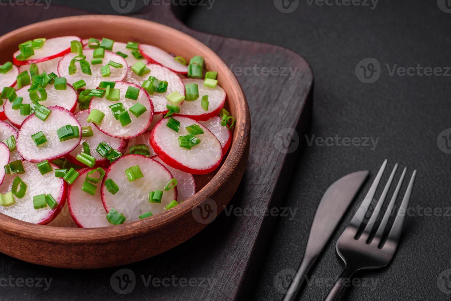 Delicious fresh salad of sliced radishes with green onions, salt and olive oil photo