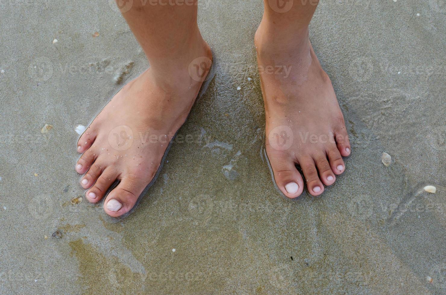Feet Standing on Sand Beach Concept Background photo