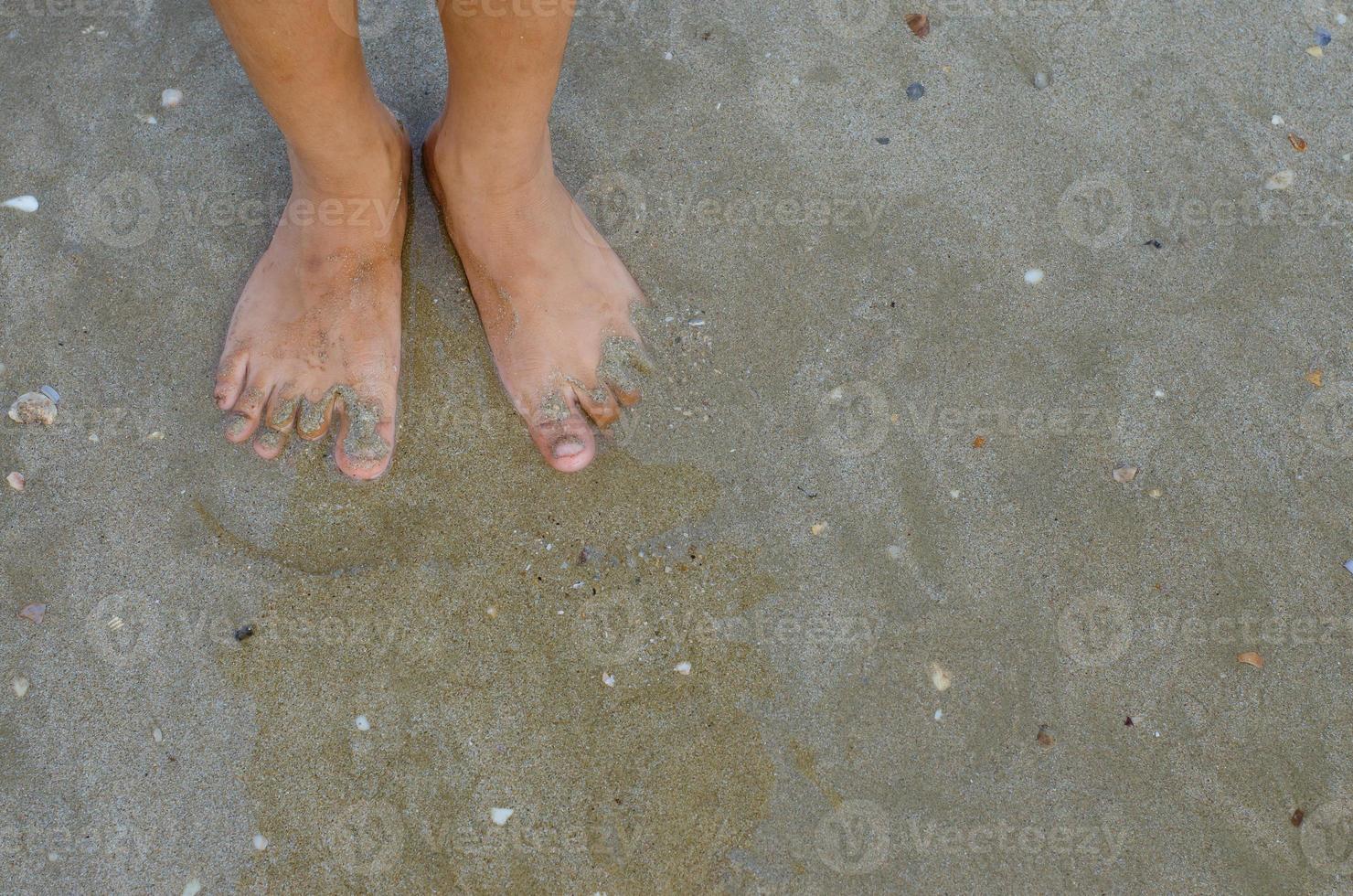 Feet Standing on Sand Beach Concept Background photo
