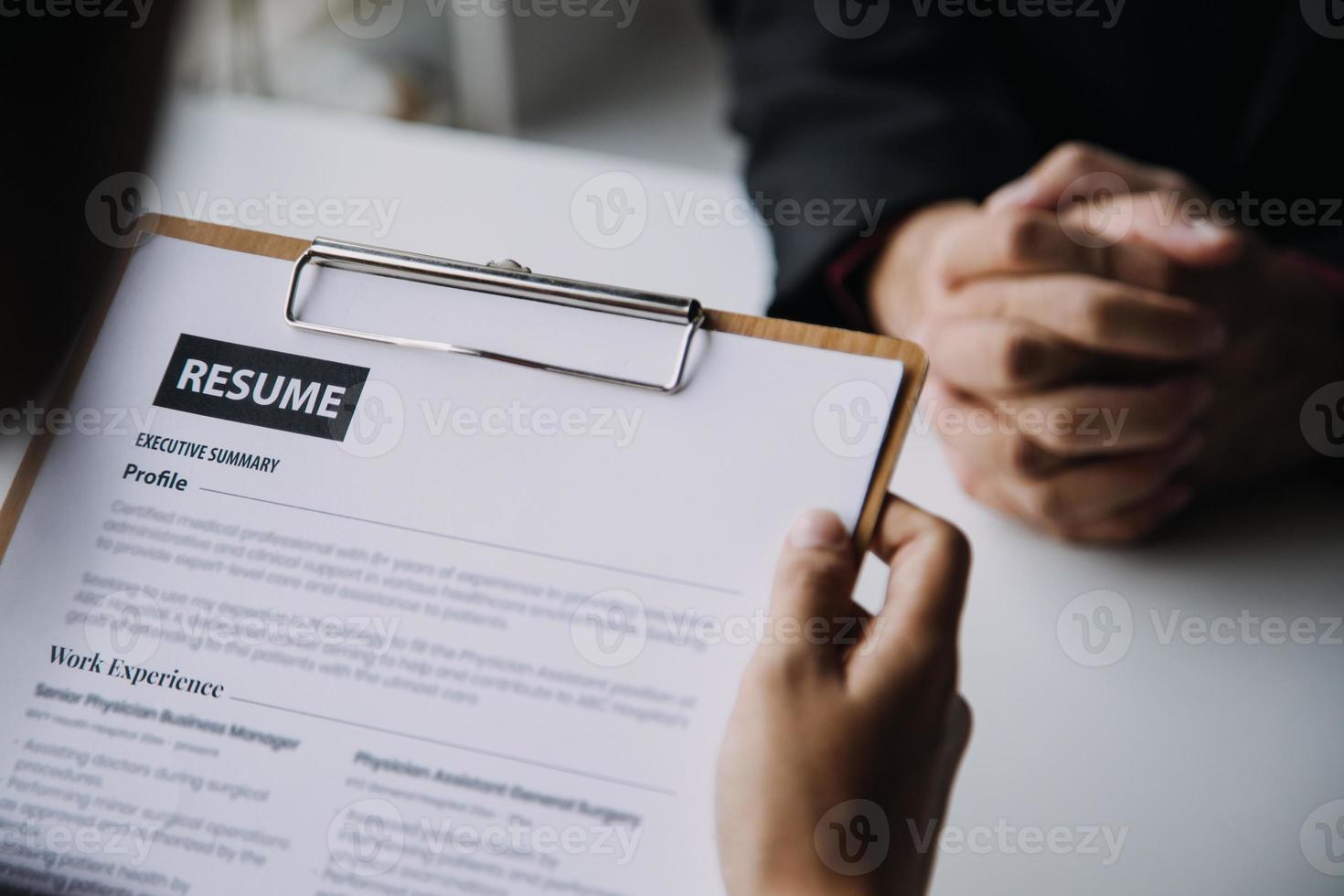 Close up view of job interview in office, focus on resume writing tips, employer reviewing good cv of prepared skilled applicant, recruiter considering application, hr manager making hiring decision photo