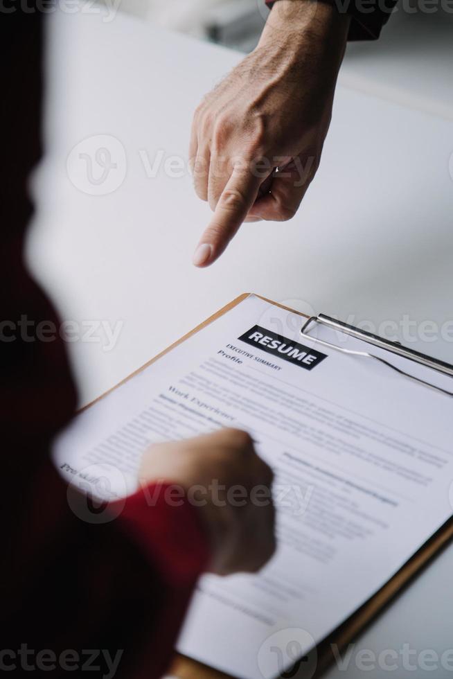 Close up view of job interview in office, focus on resume writing tips, employer reviewing good cv of prepared skilled applicant, recruiter considering application, hr manager making hiring decision photo