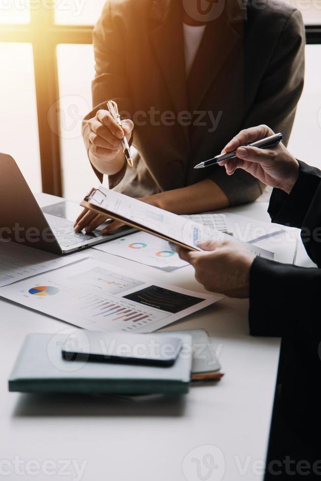 Financial analysts analyze business financial reports on a digital tablet planning investment project during a discussion at a meeting of corporate showing the results of their successful teamwork. photo