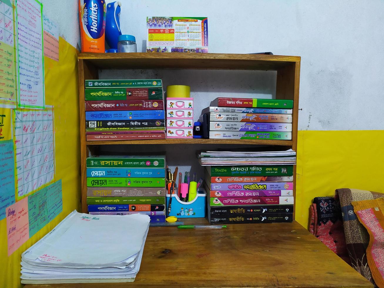 Rangpur, Bangladesh 2023. Book shelf on the table.Stack of books and pencils in holder, education concept background.Books on a wooden shelfs. photo