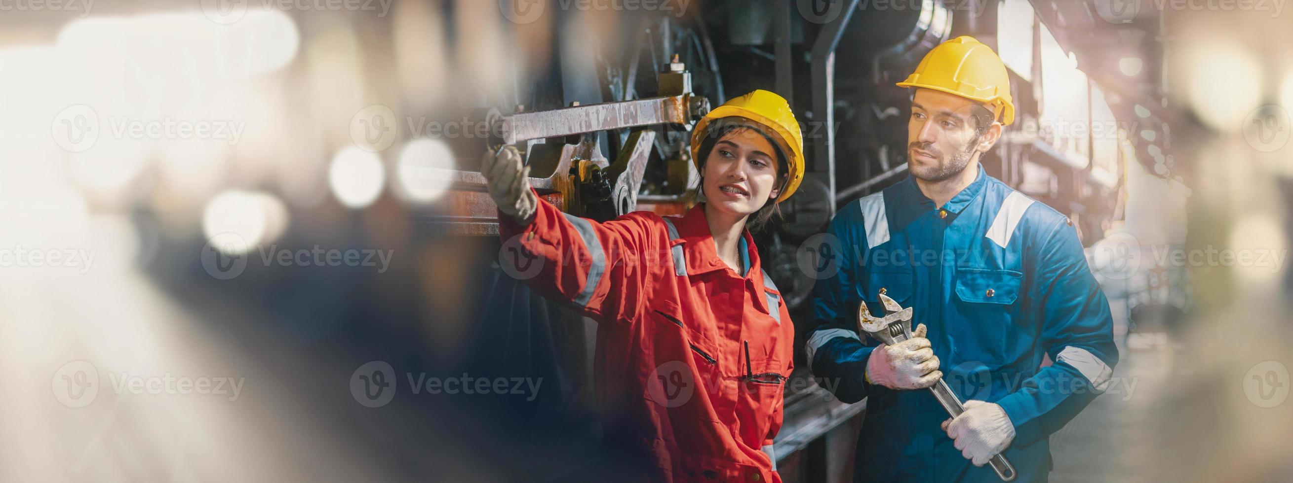 Female engineer and worker checking equipment in factory for repair photo