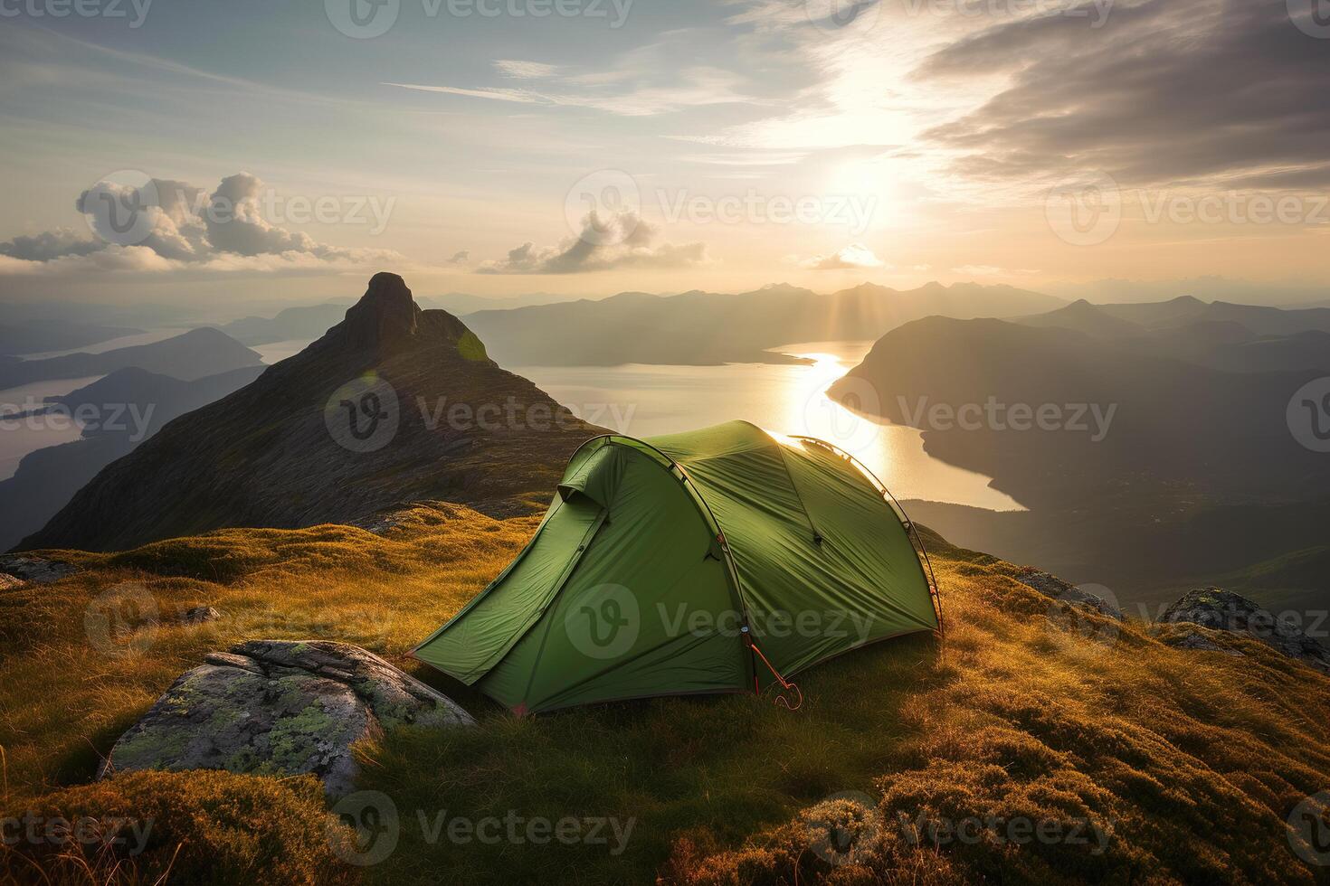 A tourist tent pitched on top of a mountain at sunrise. Tourism and physical activity concept. photo