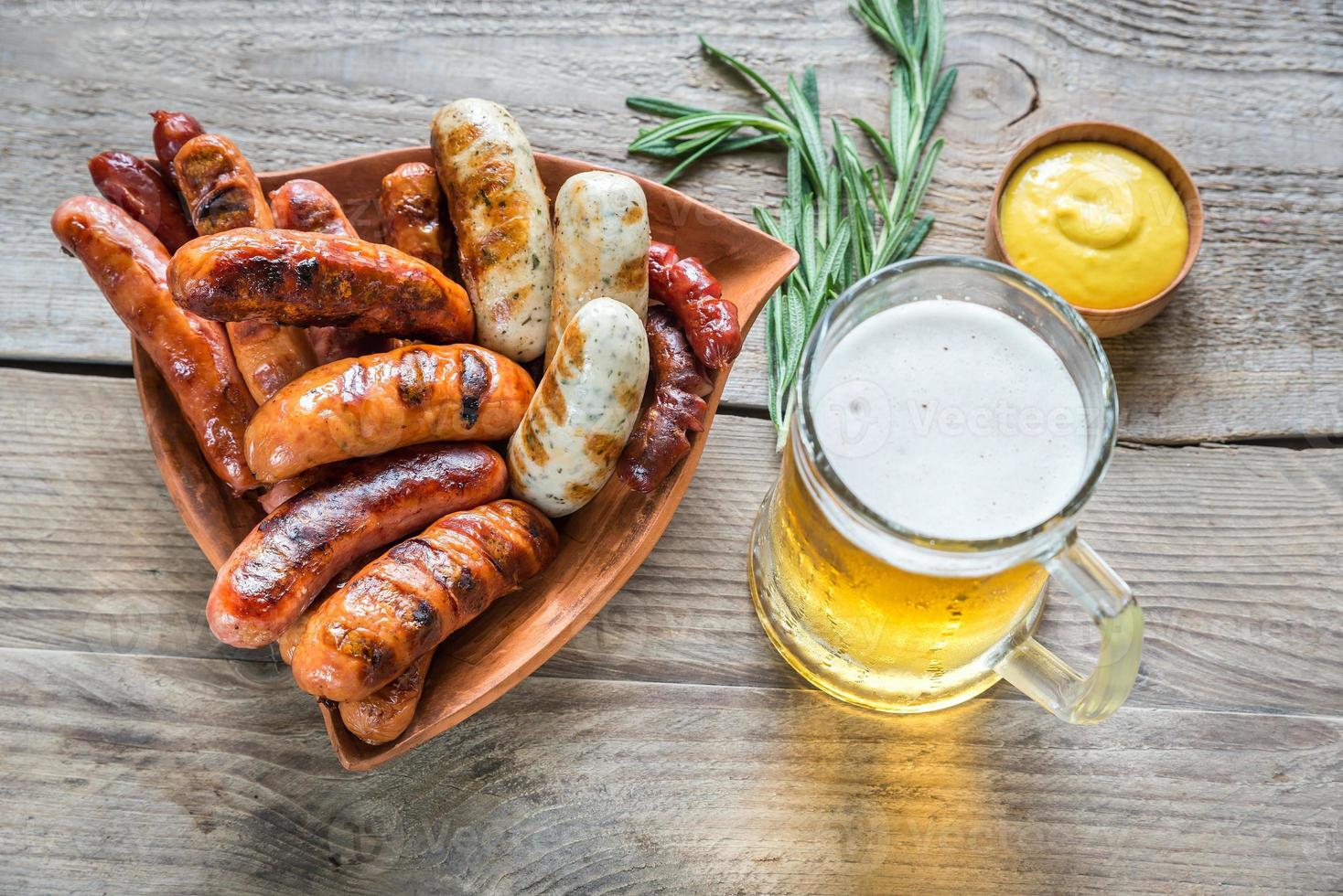 salchichas a la parrilla con un vaso de cerveza foto