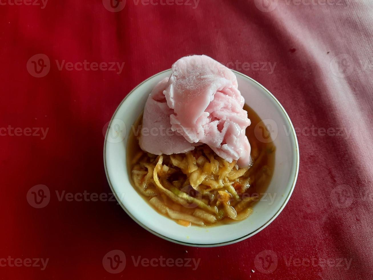 a rujak or spicy fruit salad dish topped with strawberry ice cream photo