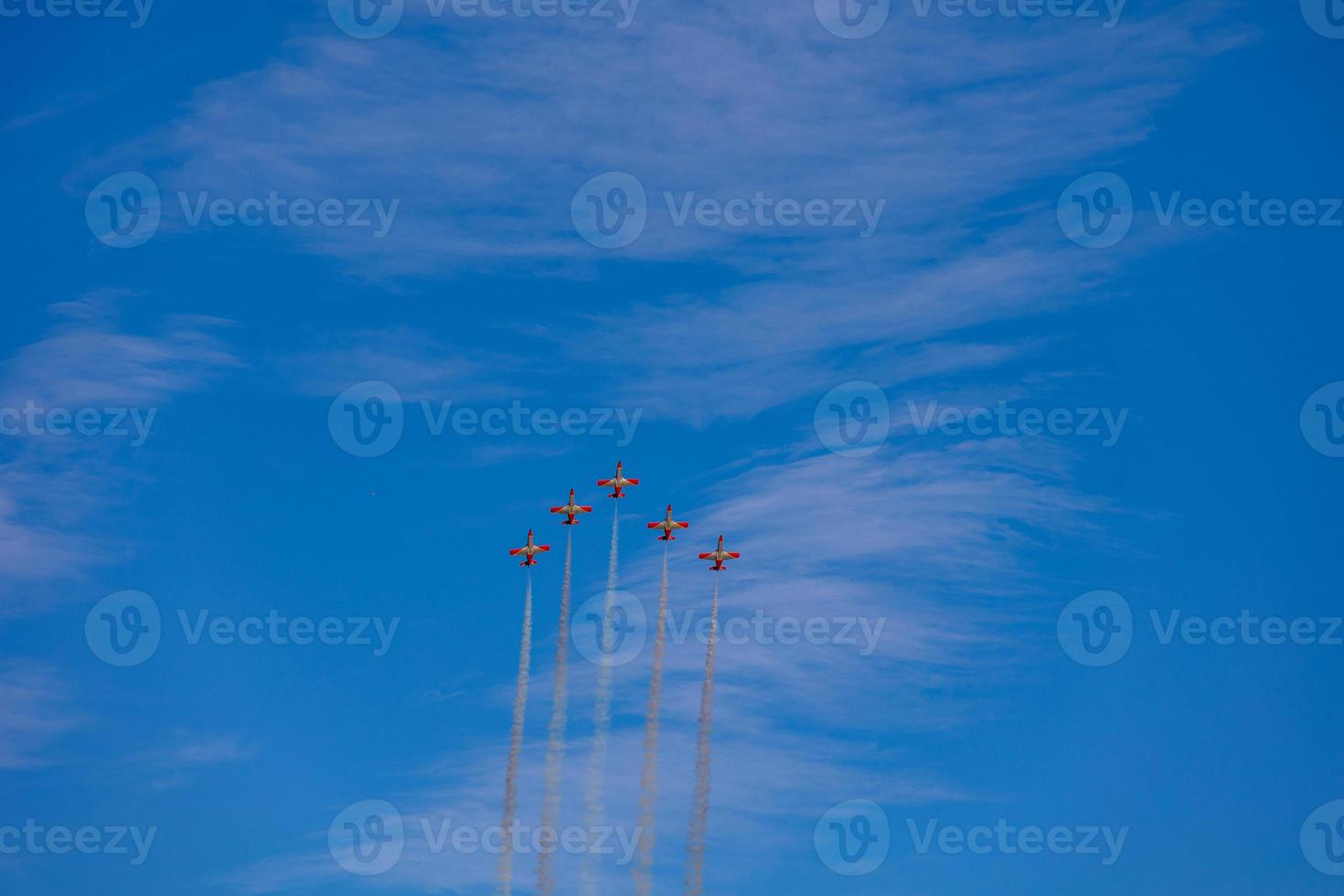 flight of five cessna planes over alicante smoke spanish flag against the blue sky photo