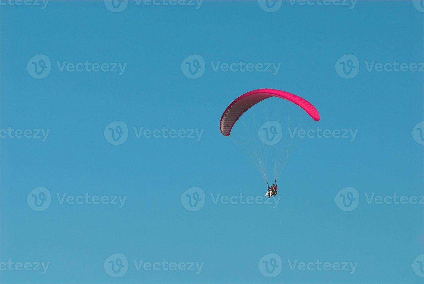paragliders in the blue cloudless sky photo