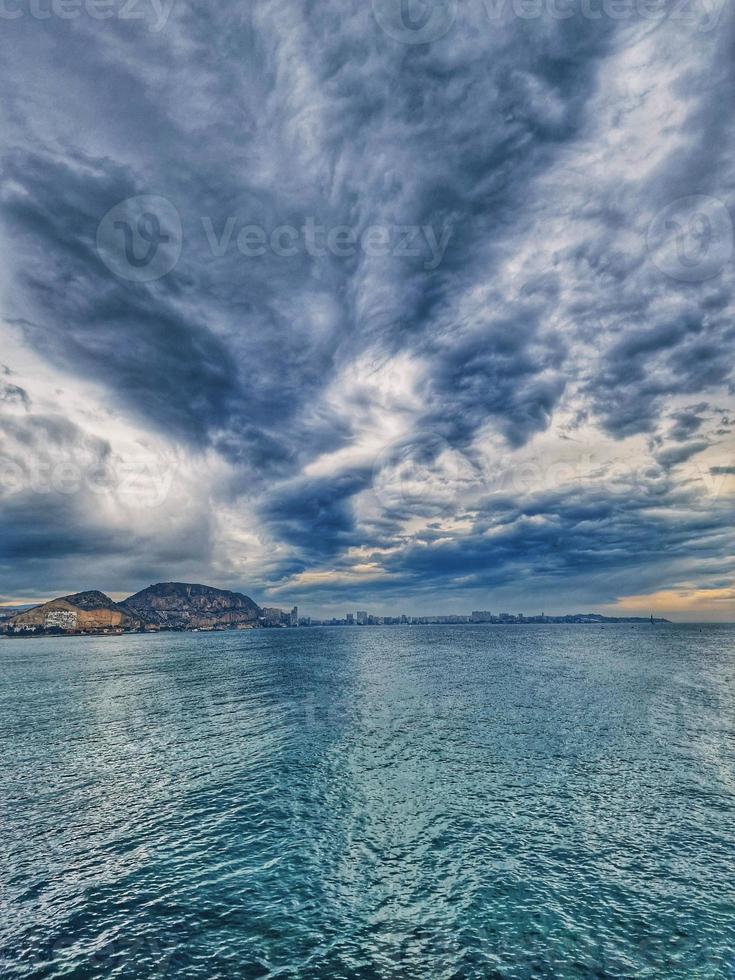 seaside landscape with clouds and sailboat on the horizon Alicante Spain photo