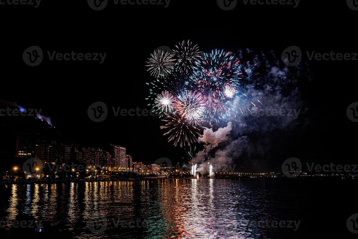 fuegos artificiales espectáculo a noche en el costas de el mar de alicante España foto