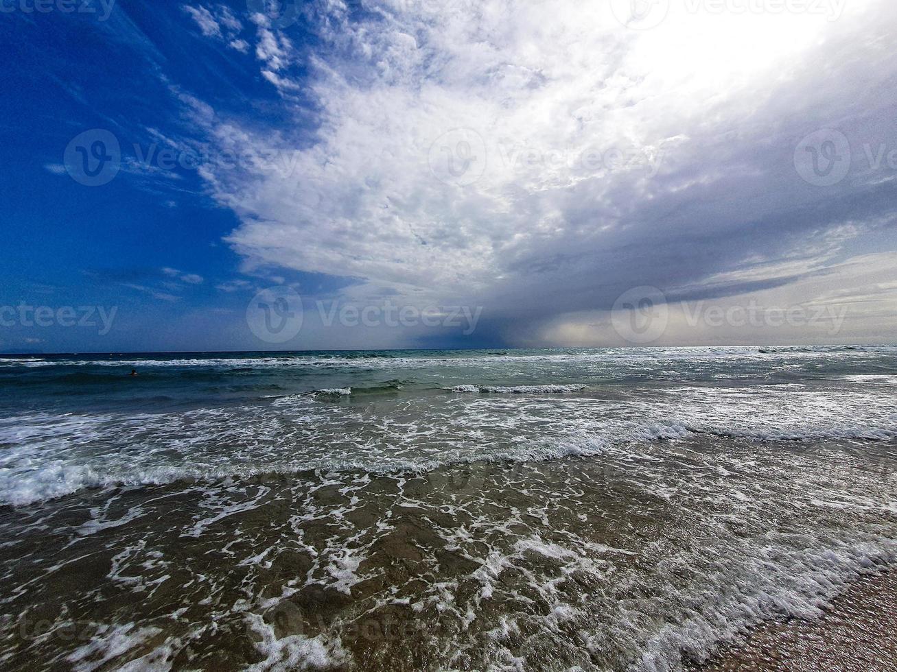 serene seaside landscape with sky with clouds and waves photo