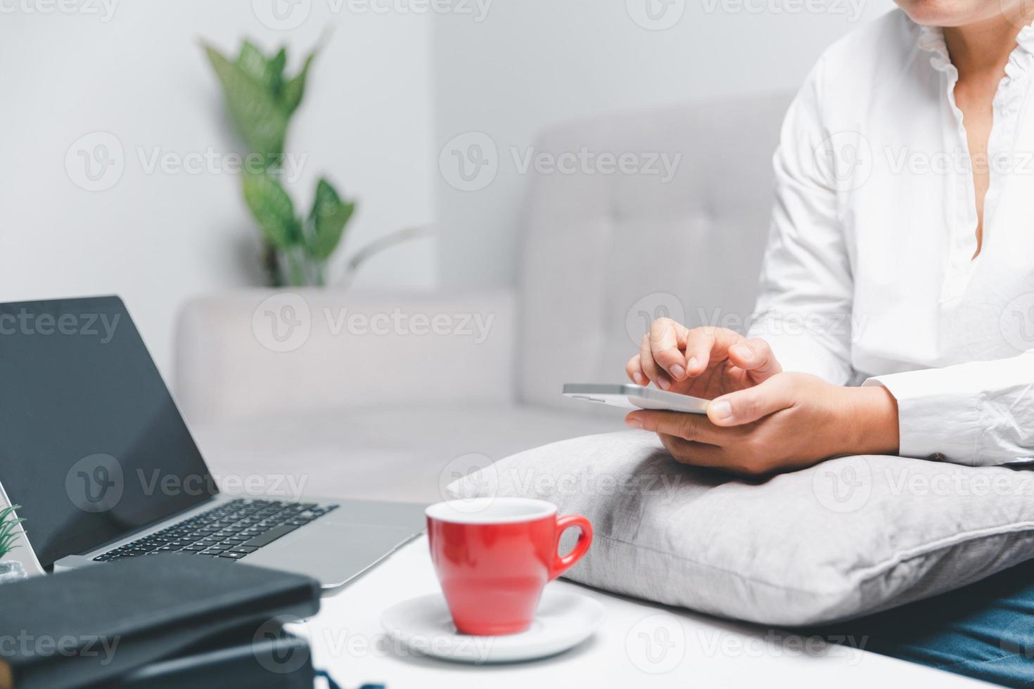 Social media day concept. Female freelancer starting working day early in living room for website with smartphone. Businesswoman working in home office. Woman communicating with online technology. photo