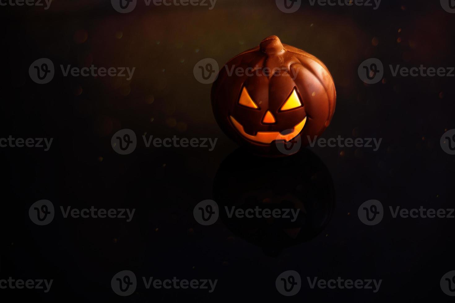 chocolate Víspera de Todos los Santos calabaza Jack-o-lantern en oscuro antecedentes foto