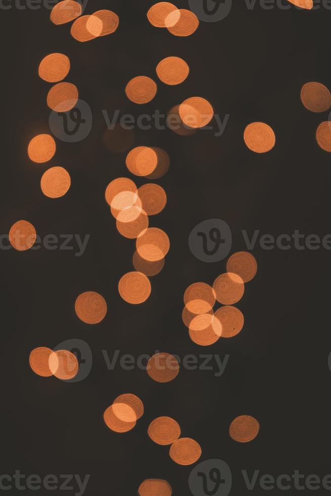 orange background festive bokeh light effect on dark background photo