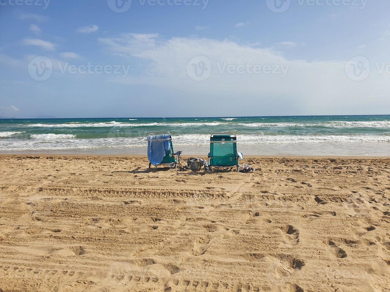 l playa paisaje con dos Dom tumbonas en el playa en el costas de el turquesa mar en un calentar verano día foto