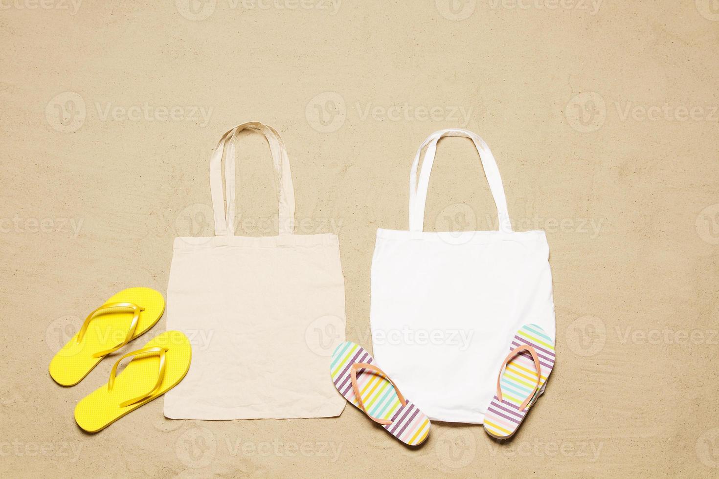 Mockup shopper handbag beach sand background. Top view copy space shopping eco reusable bag. Flip flops accessories. Template blank top view white cotton material canvas cloth. Empty mock-up beach photo