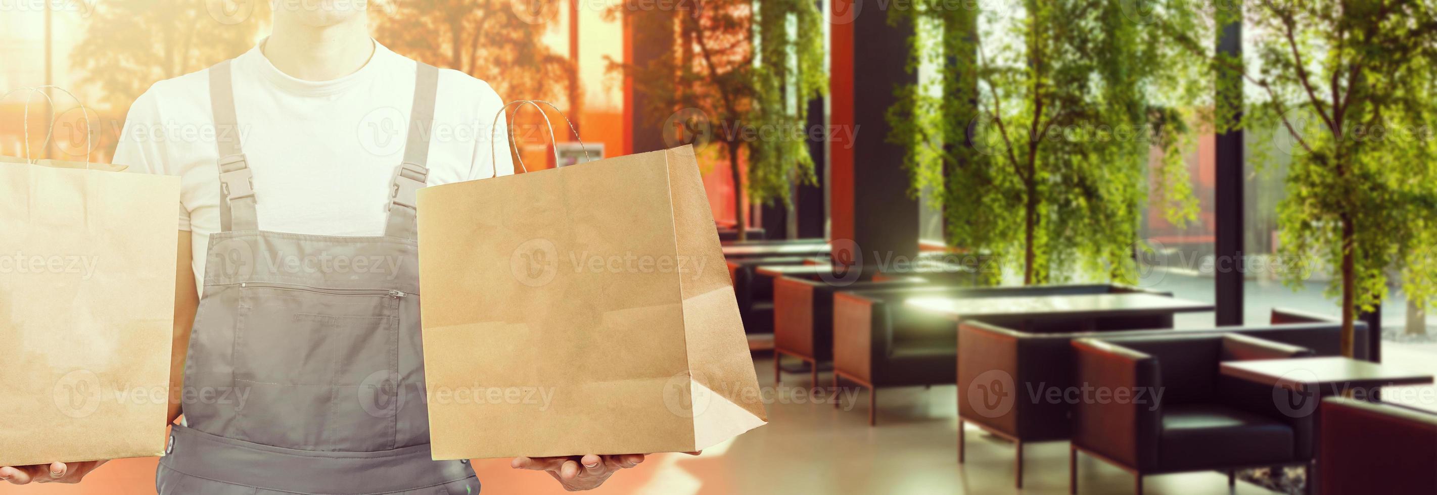 delivery, mail and people concept - happy man delivering food in disposable paper bag to customer home photo