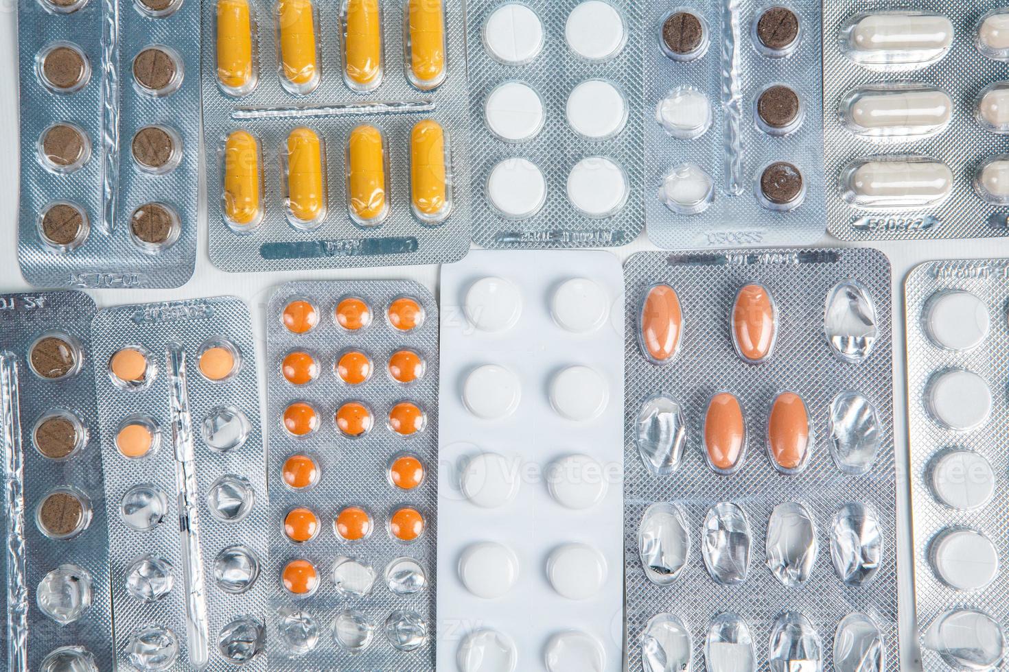 Pills in blister pack on white background. Tablets and capsules in blister packs. Top view, copy space. photo