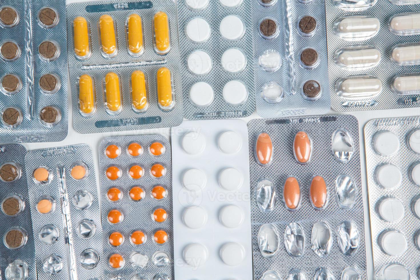 Pills in blister pack on white background. Tablets and capsules in blister packs. Top view, copy space. photo