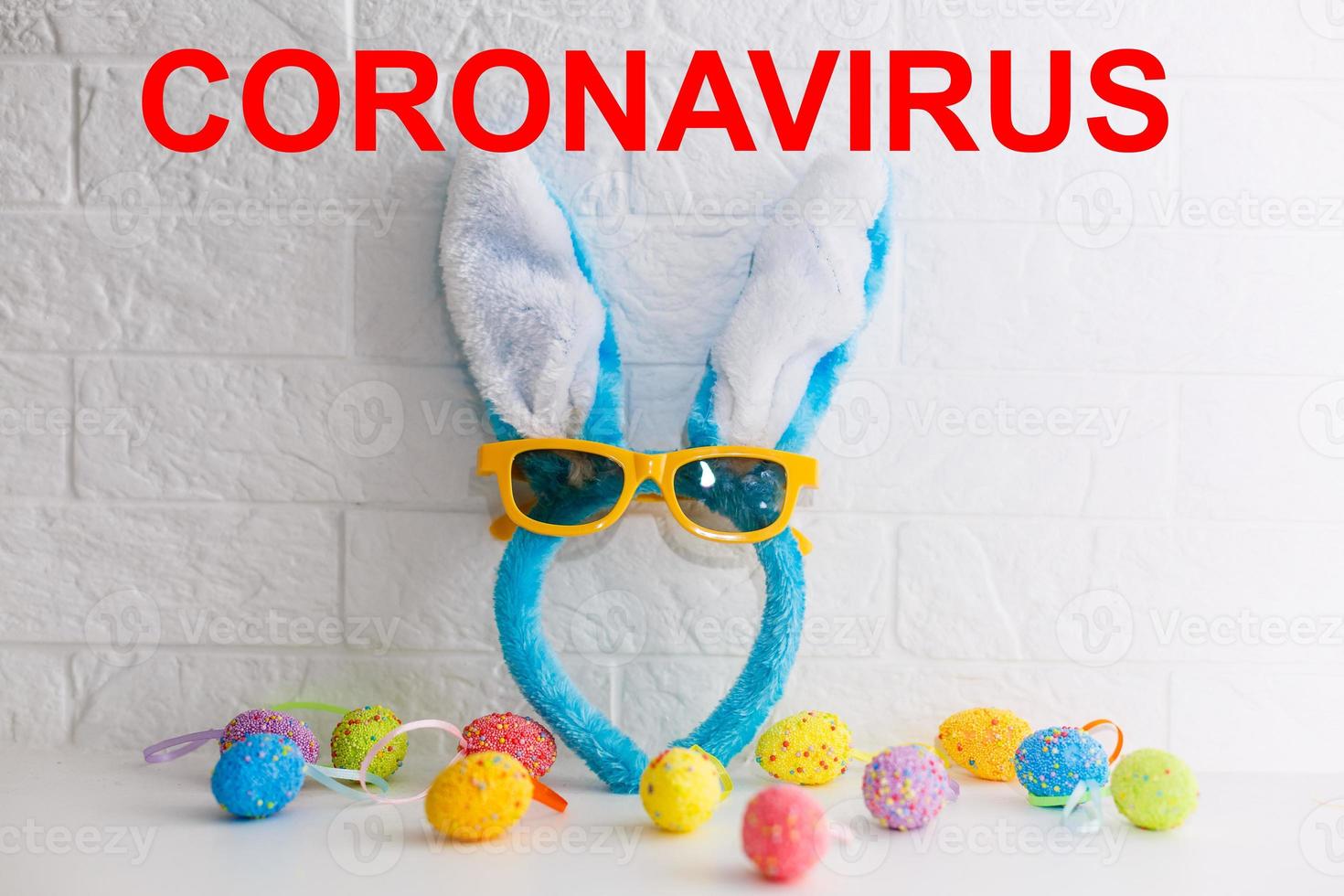 Layout of coronavirus and Easter eggs on the table with a note, close-up. Concept on the possible ban on festive events due to COVID-19 photo