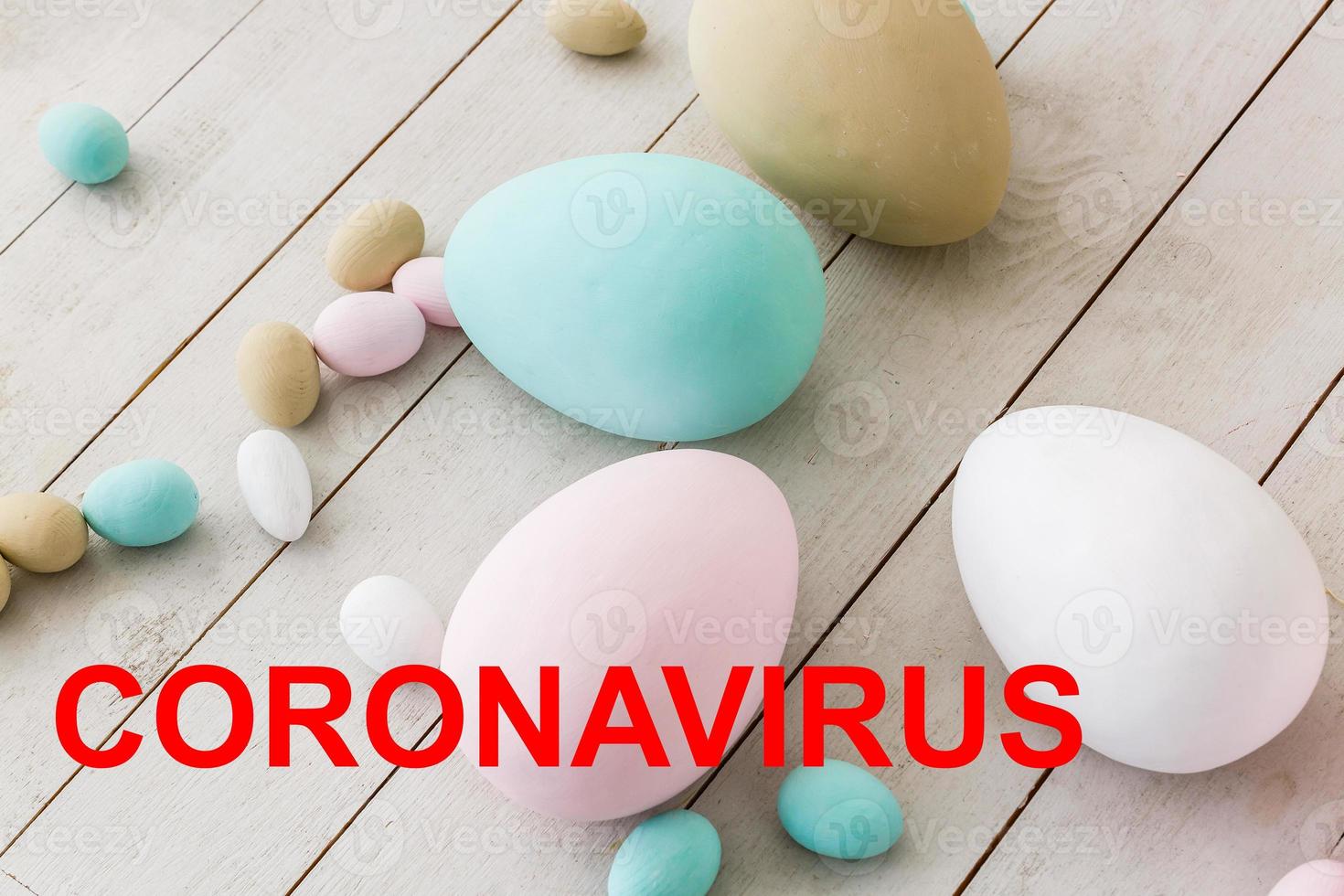 Layout of coronavirus and Easter eggs on the table with a note, close-up. Concept on the possible ban on festive events due to COVID-19 photo