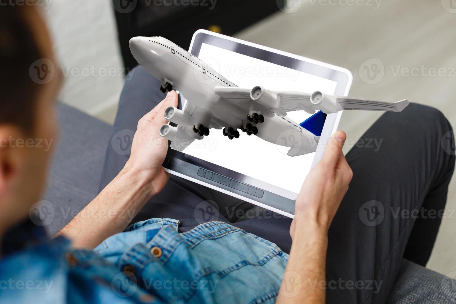 take off planes from digital tablet monitor in human hands at city background photo