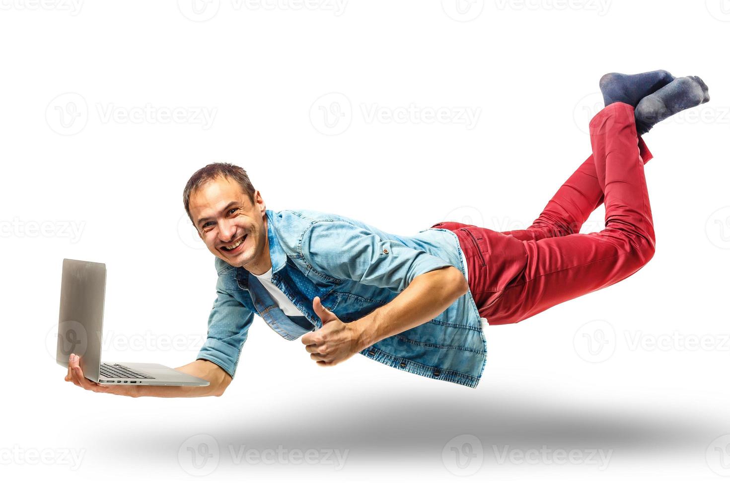 Smiling young man with his laptop against a white background photo