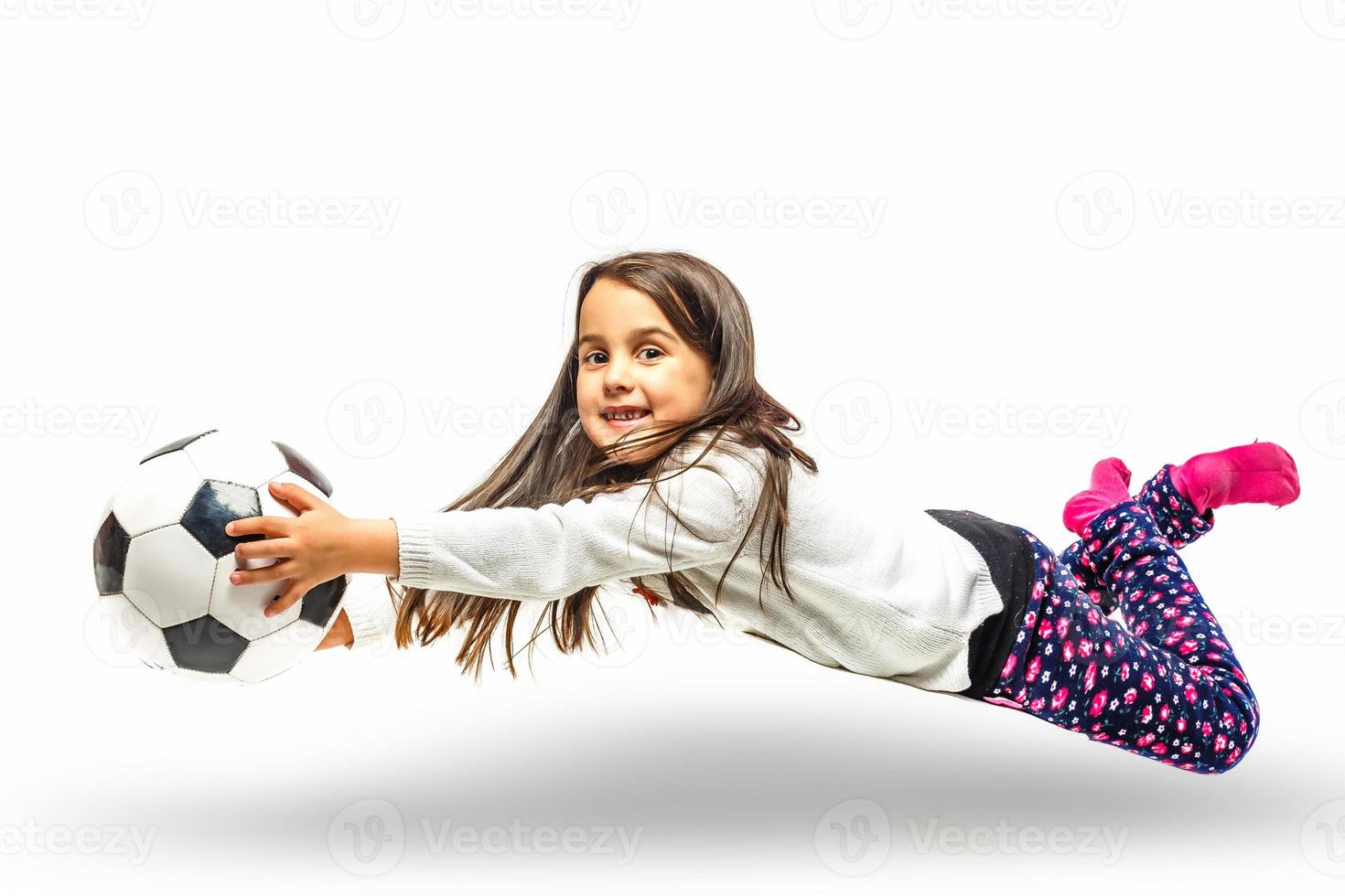 Brunette little girl with a soccer ball isolated on a over white background photo