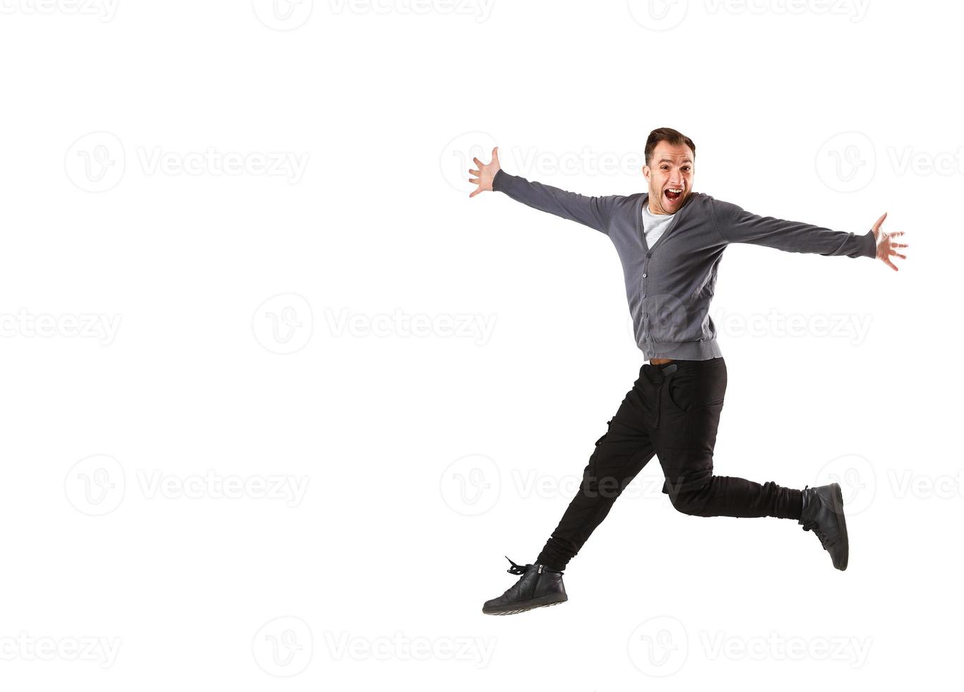 Excited young man jumping and smiling isolated photo