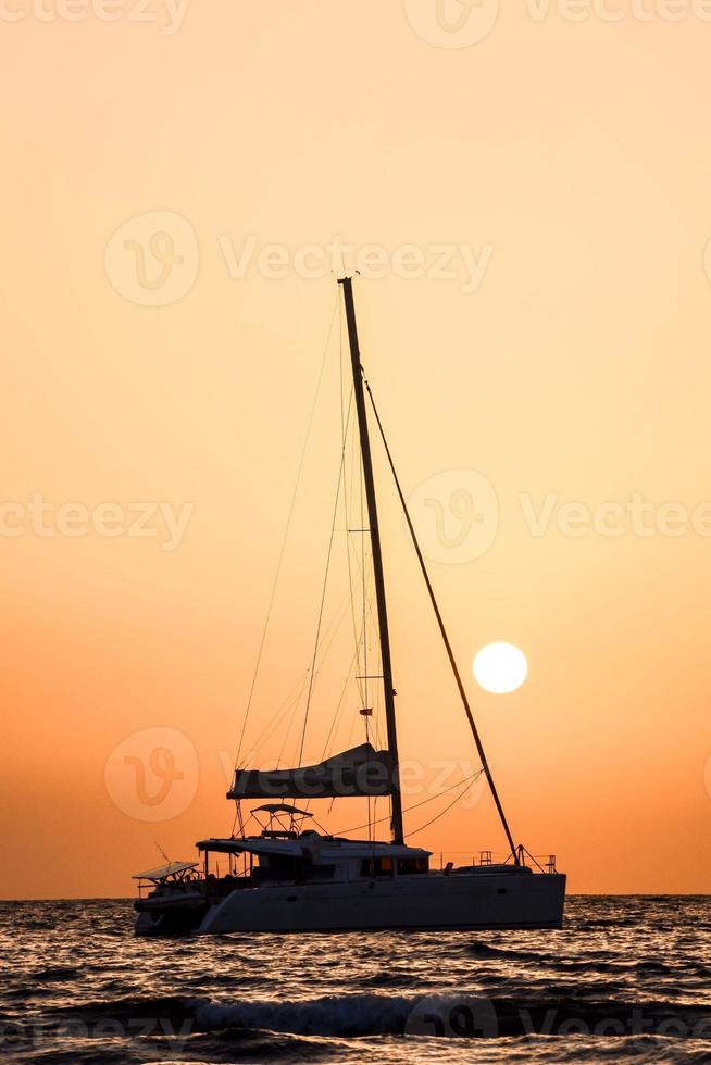 Sailing yacht at sunset photo