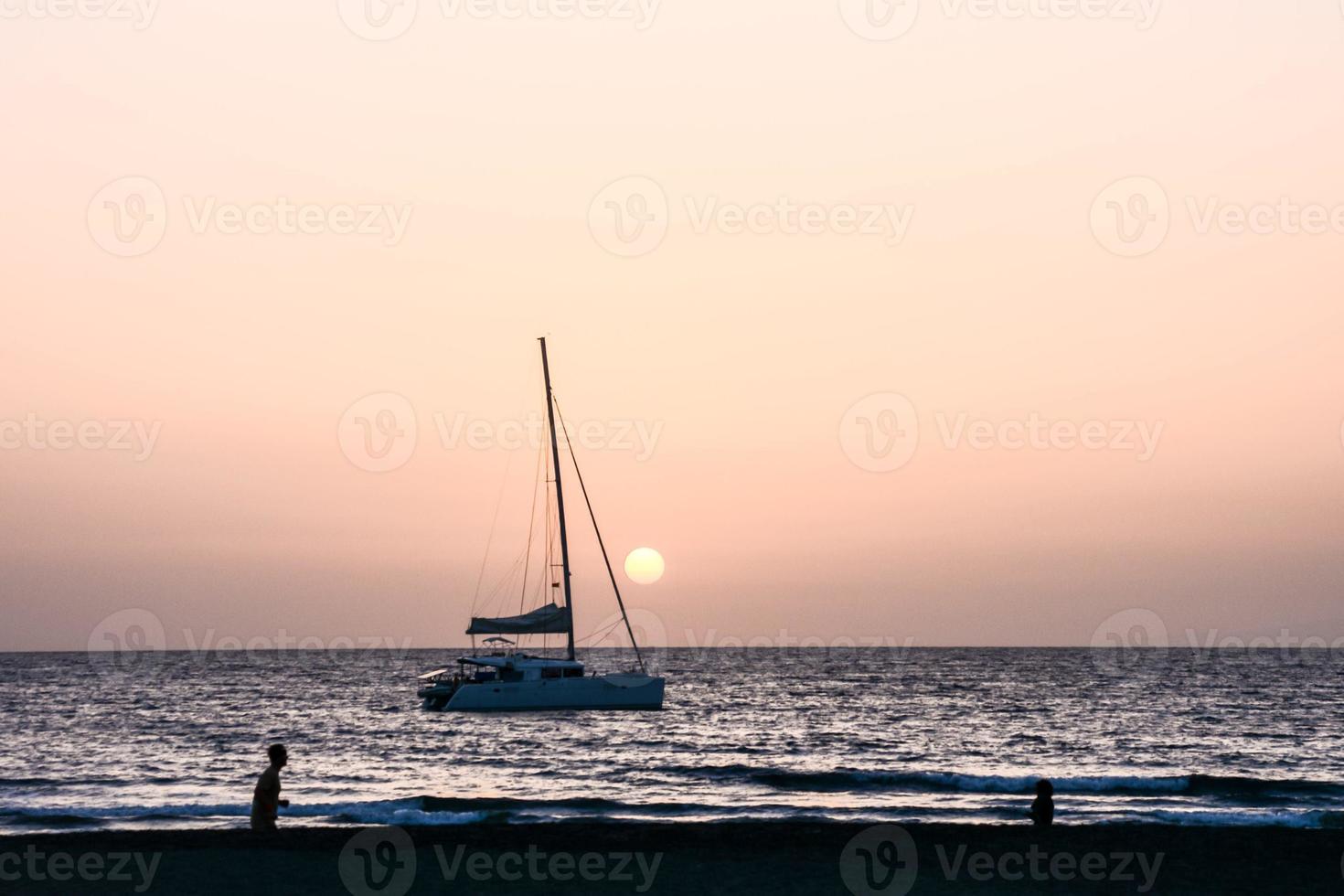 Sailing yacht at sunset photo