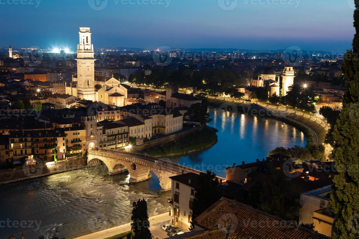 verona, italia - panorama por la noche. paisaje urbano iluminado con puente escénico. foto