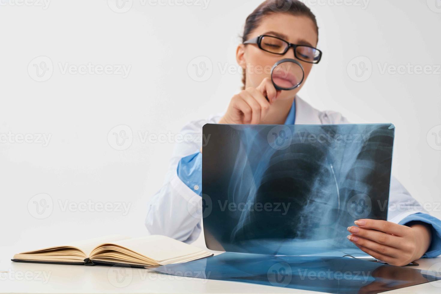 mujer médico sentado a el mesa radiólogo diagnósticos profesionales foto