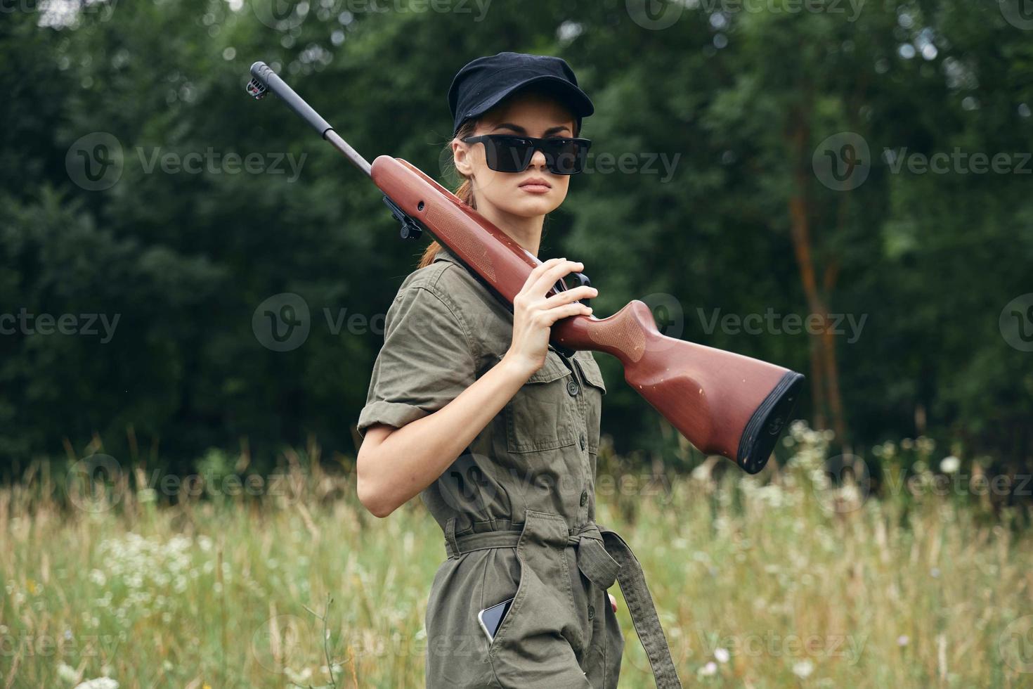 Woman soldier The weapon is wearing a green jumpsuit in sunglasses photo