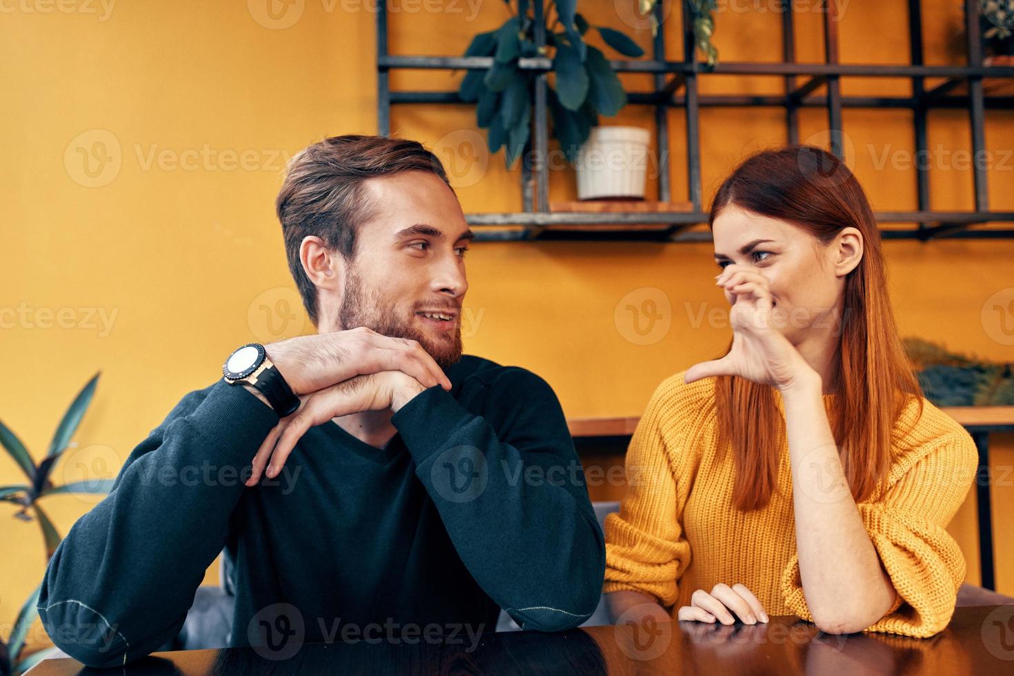 cheerful man and woman gesturing with their hands and sitting at a table in a cafe communication friends a cup of coffee photo