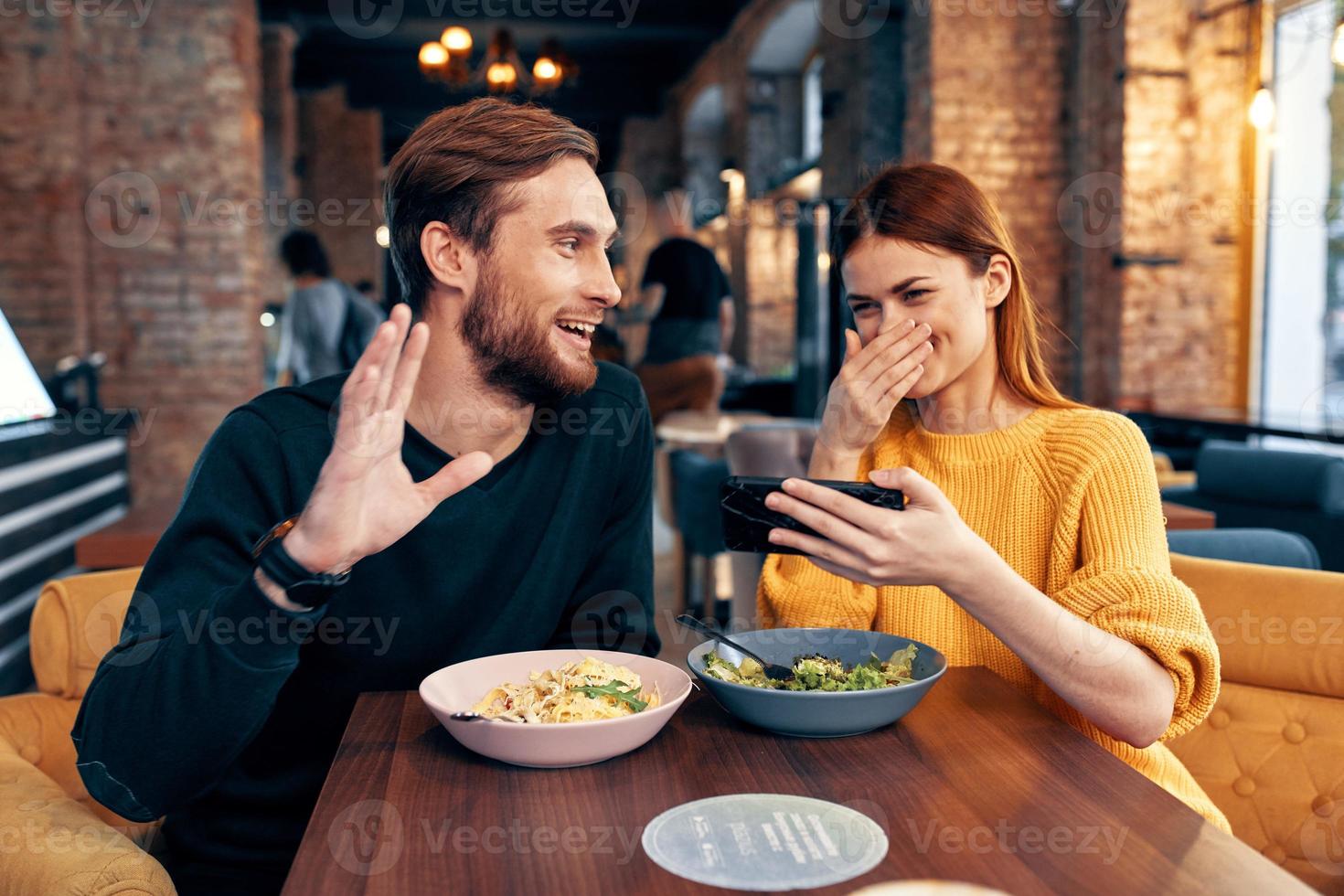 cute men and women in a restaurant with a phone in their hands selfie photo