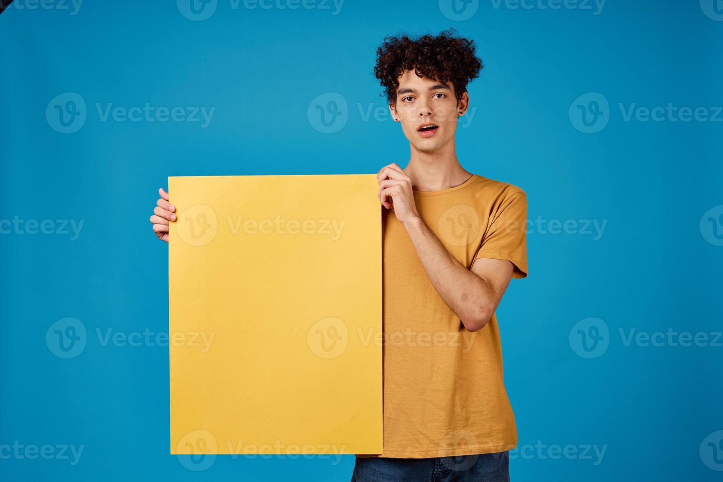 guy with curly hair yellow Poster mockup advertising blue background photo