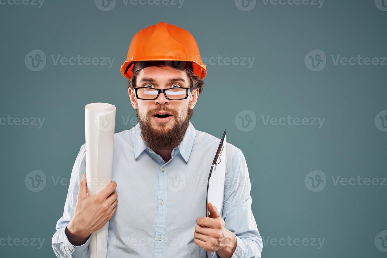 emocional hombre vistiendo lentes naranja casco la seguridad planos en manos profesional trabajo foto