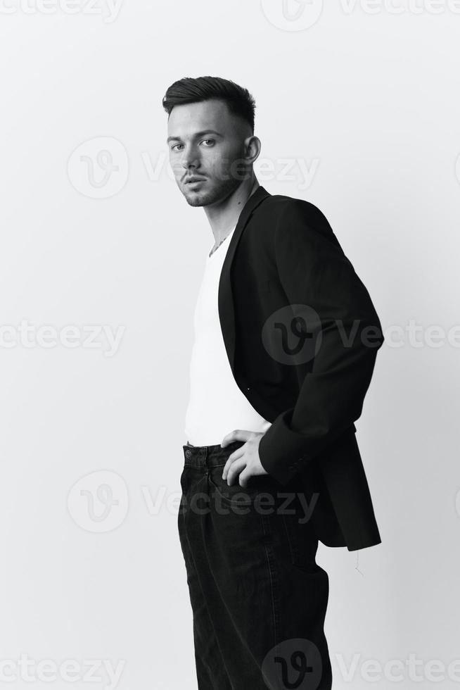 Modelling snapshots. Side of view narcissistic attractive handsome man in classic suit hold hands on belt posing isolated in white studio background. Black White concept. Fashion offer. Copy space photo