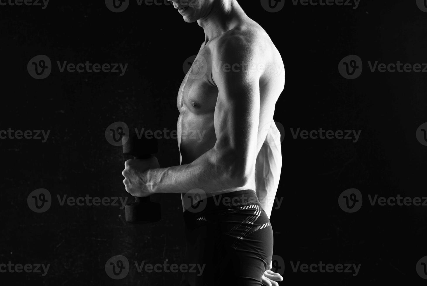 man with dumbbells in hands pumping up muscles exercises photo