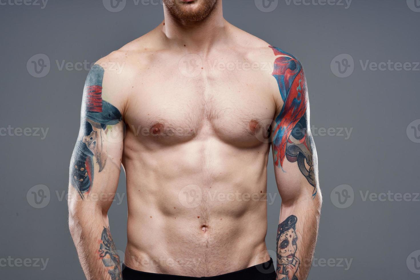 man with tattoos on his arms naked torso pumping up abs workout photo