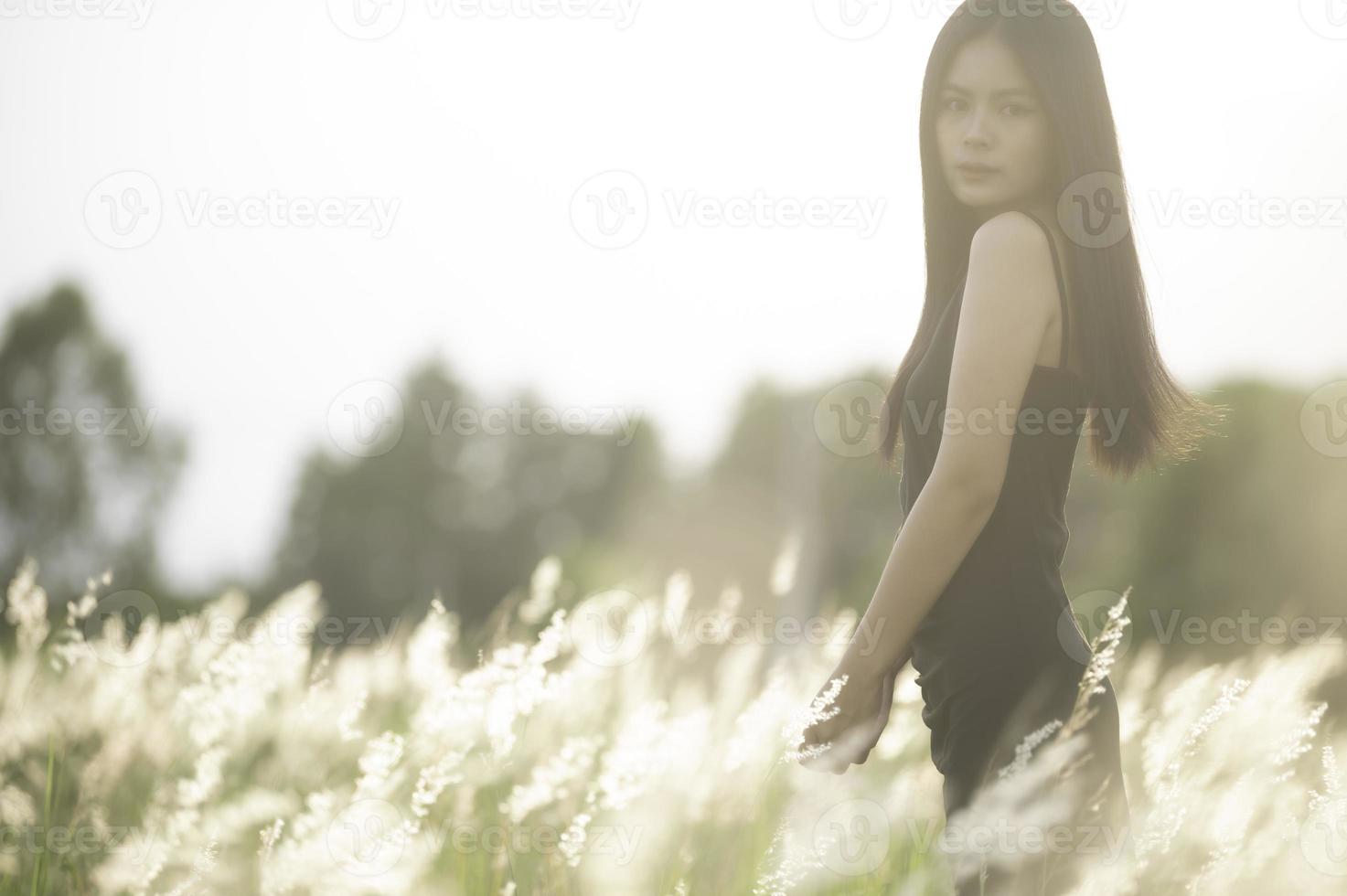 Portrait of beautiful asian woman at grass field on sunset photo