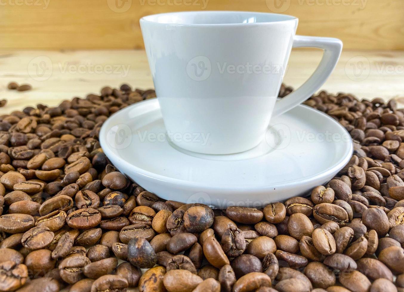 Coffee in a cup with a saucer and coffee grains on the table. photo