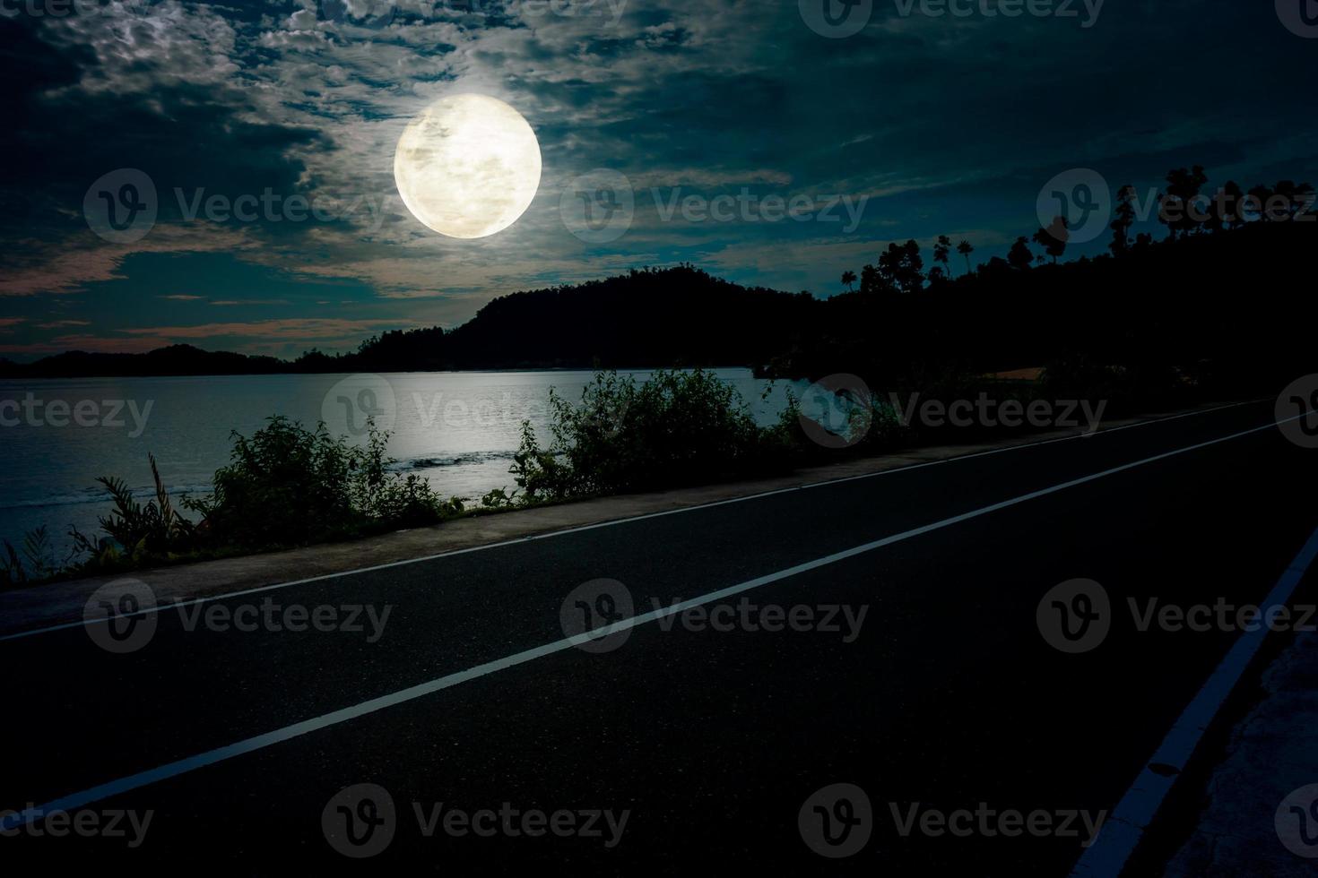 Night landscape at beach with empty road and full moon photo