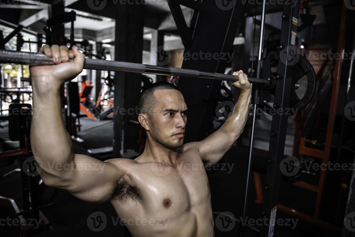 retrato de asiático hombre grande músculo a el gimnasio,tailandia gente,entrenamiento para bueno cuerpo saludable peso entrenamiento, fitness a el gimnasio concepto, broma a abdominal músculos foto