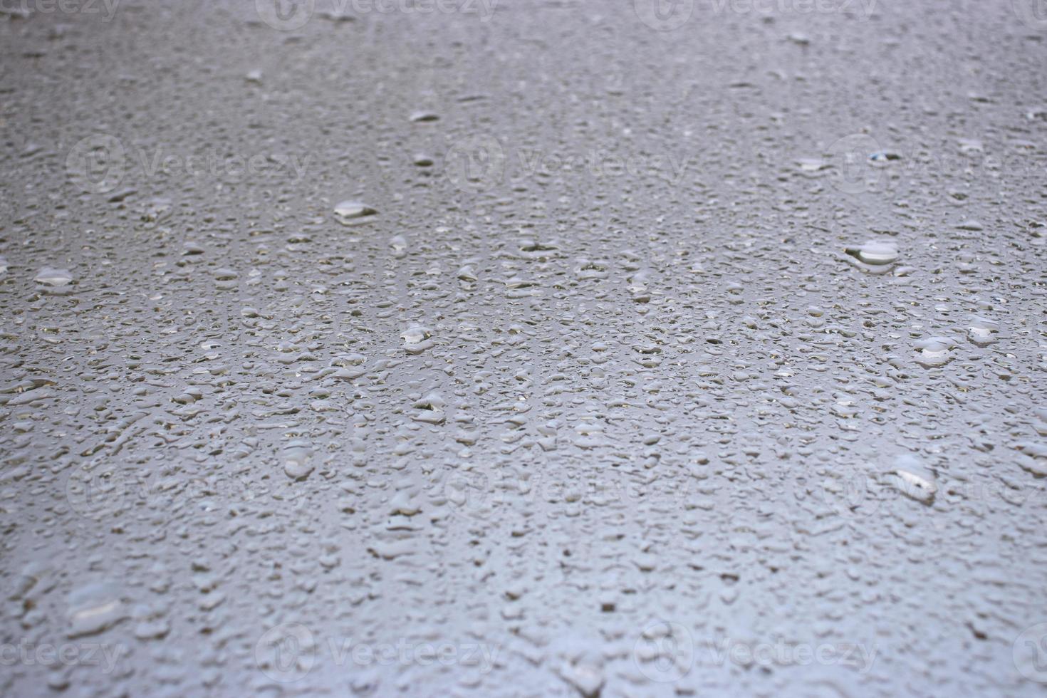 Close-up view on water drops on window in rain. Drops of rain on the glass concept photo. Front view photography with blurred background. photo