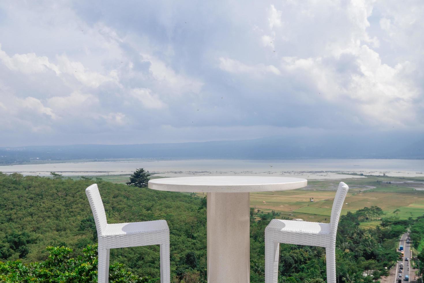 Empty white chair and table with beautiful background and cloudy sky