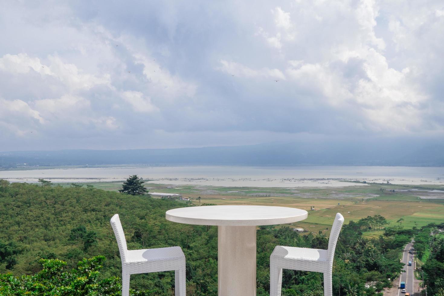 Empty white chair and table with beautiful background and cloudy sky